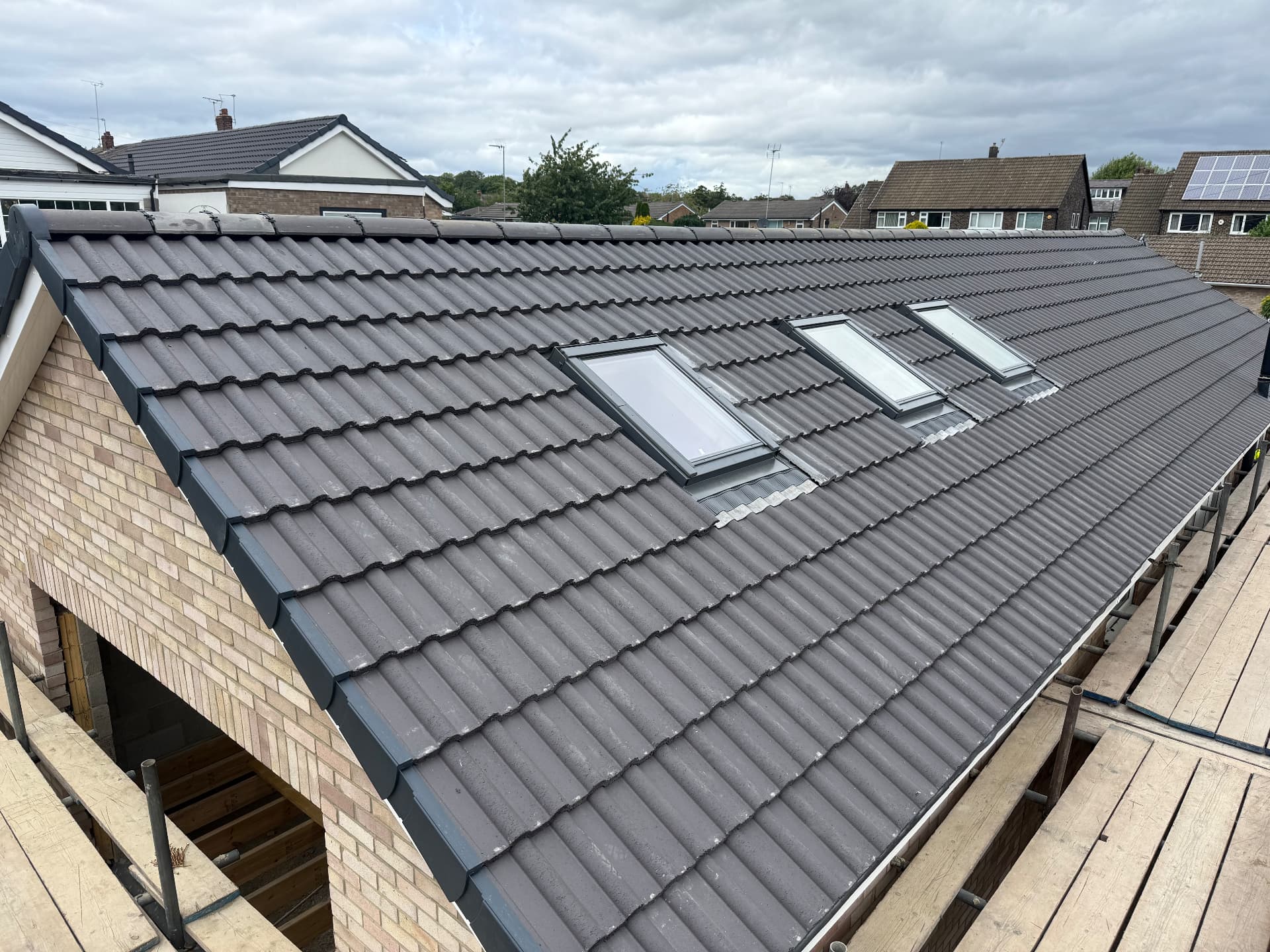 Newly tiled grey roof with velux windows completed in Leeds